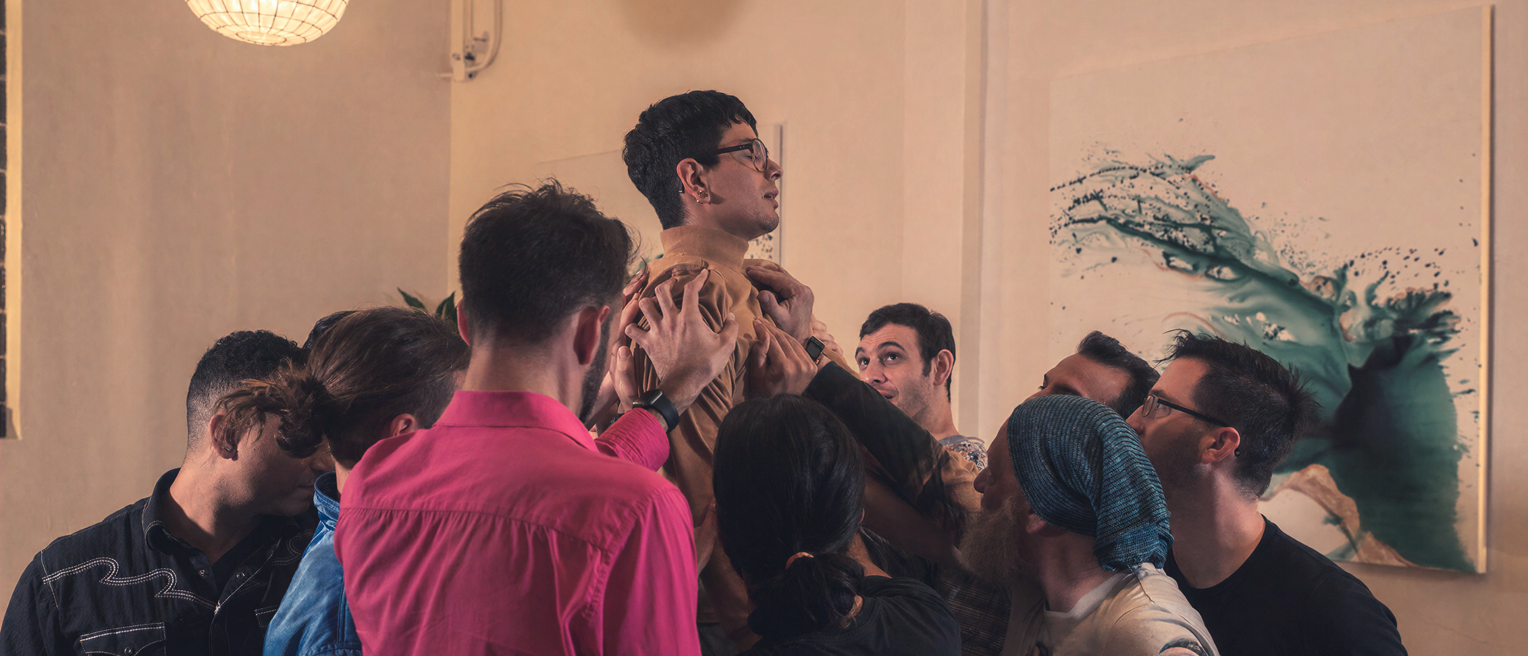 A group of people in intimate connection, hands on one another in a circle of trust and support